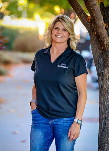 Traci McMahan, Owner and Founder of Paso Robles Tech, standing outdoors in a Paso Robles Tech polo shirt