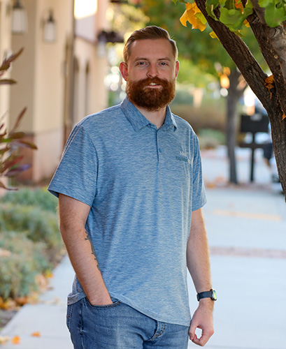 Matt Mosher, Cybersecurity and Systems Administrator at Paso Robles Tech, photographed outdoors in a Paso Robles Tech polo shirt