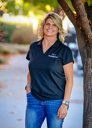 Traci McMahan, Owner and Founder of Paso Robles Tech, standing outdoors in a Paso Robles Tech polo shirt